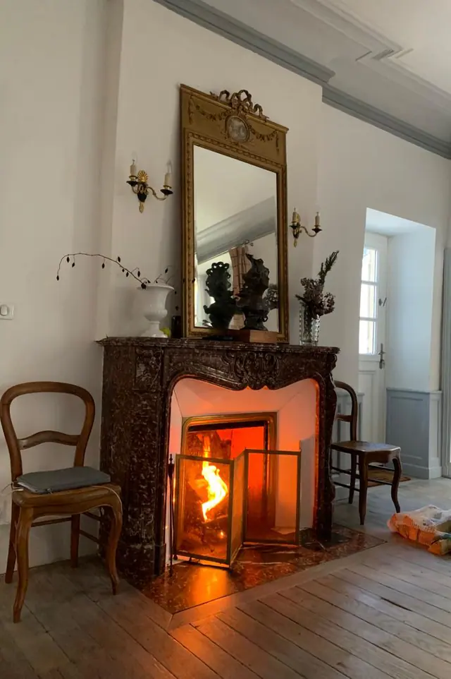 Un feu allumé dans la cheminée en marbre du salon