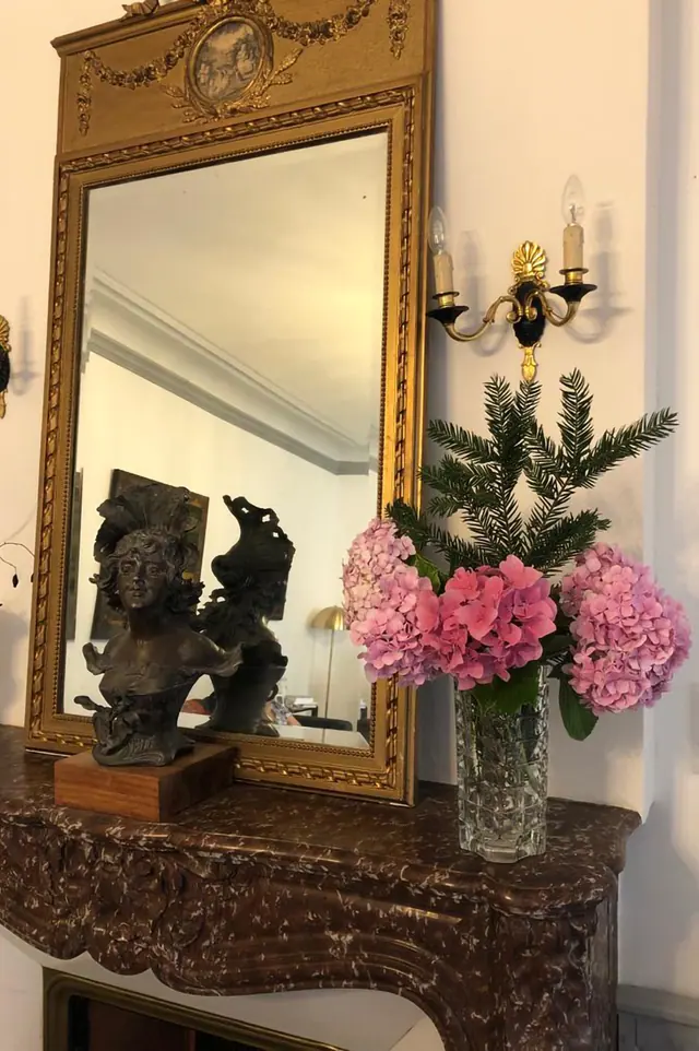 Sculptures et bouquets devant un miroir doré